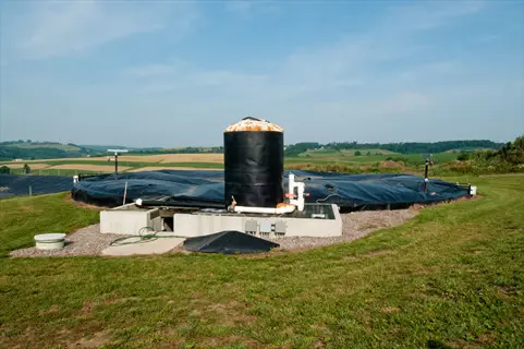 biogas digester rural setup with covered tanks and central silo in farmland