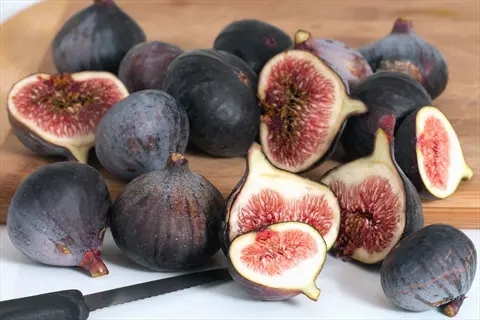 fresh fig tree fruit, whole and sliced figs on a cutting board