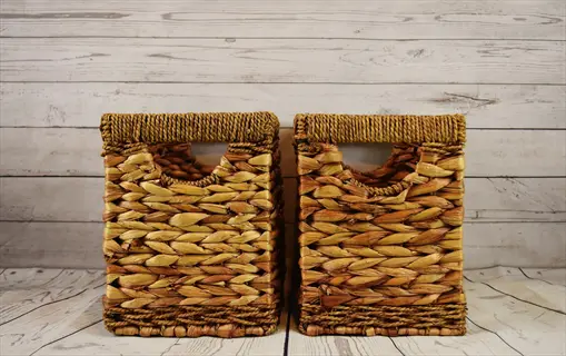 two woven water hyacinth basket storage bins on a light wood floor